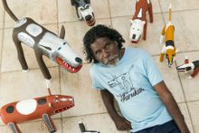Aurukun artist Garry Namponan with his camp dog carvings from the Wik and Kugu Arts Centre.