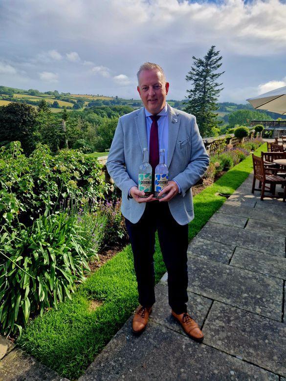 Dean Gunston, General Manager of Bovey Castle Hotel, with bottles of Devonia Water.jpg