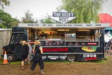 Black Beefy Boys food truck in a field with several customers in a queue