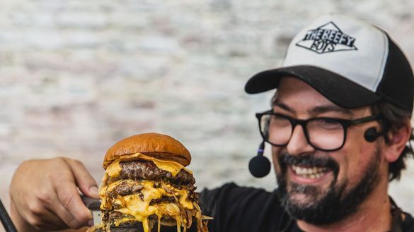 Beefy Boys co-founder Murf proudly holds up a stacked cheeseburger with dripping sauce. Beefy Boys co-founder Murf proudly holds up a stacked cheeseburger with dripping sauce.